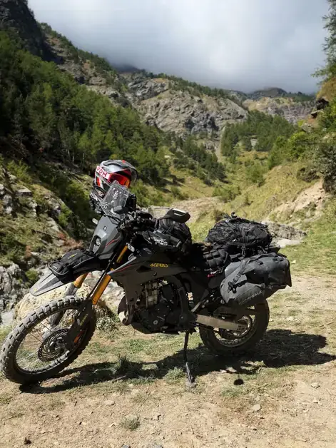 Enduro motorcycle on a dirt trail on Monte Jafferau in Bardonecchia, among forests and mountains